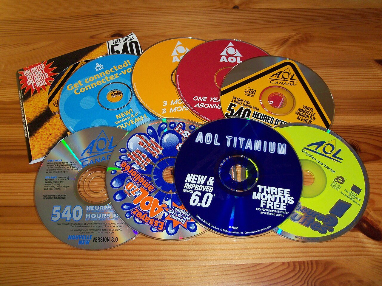A pile of AOL promotional CD-ROMs in paper and plastic sleeves advertising free trial hours