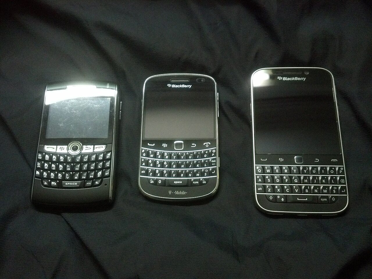 A BlackBerry 8820, a BlackBerry Bold 9900 and a BlackBerry Classic, all with physical QWERTY keyboards