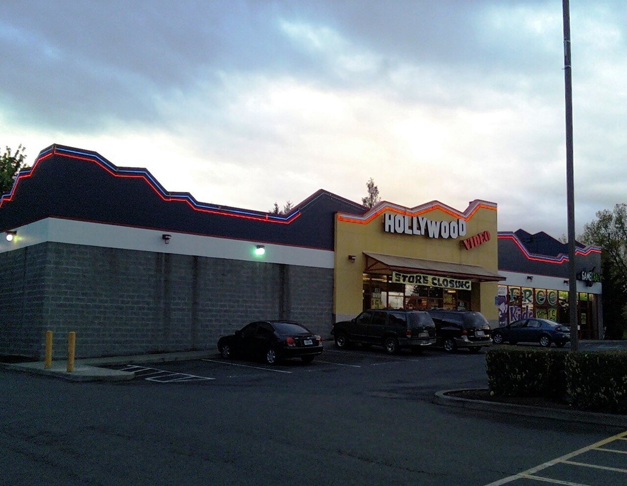 A Hollywood Video rental store with its illuminated storefront sign