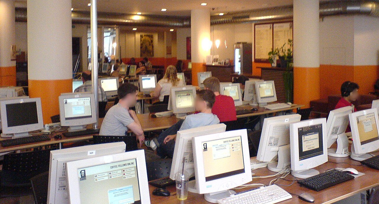 An internet cafe in the mid-2000s with people using desktop computers