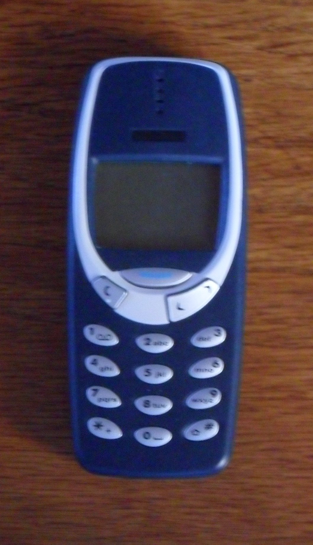 The original Nokia 3310 mobile phone in dark blue with a monochrome screen and physical keypad