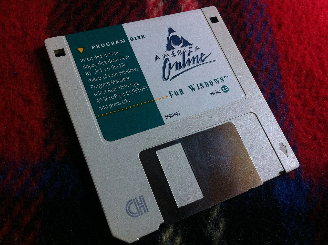 An America Online version 2.0 program floppy disk for Windows resting on a wooden surface