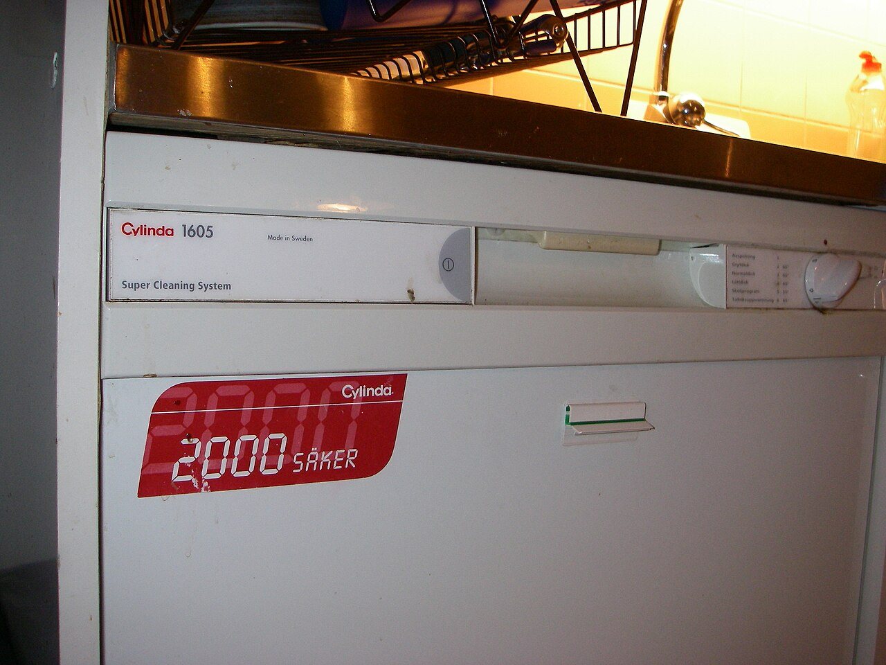 A white Cylinda dishwasher with a red sticker reading 2000 SAKER on its door